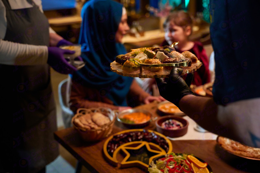 In a heartwarming scene, a professional chef serves an European Muslim family their iftar meal during the holy month of Ramadan, embodying cultural unity and culinary hospitality in a moment of shared celebration and gratitude